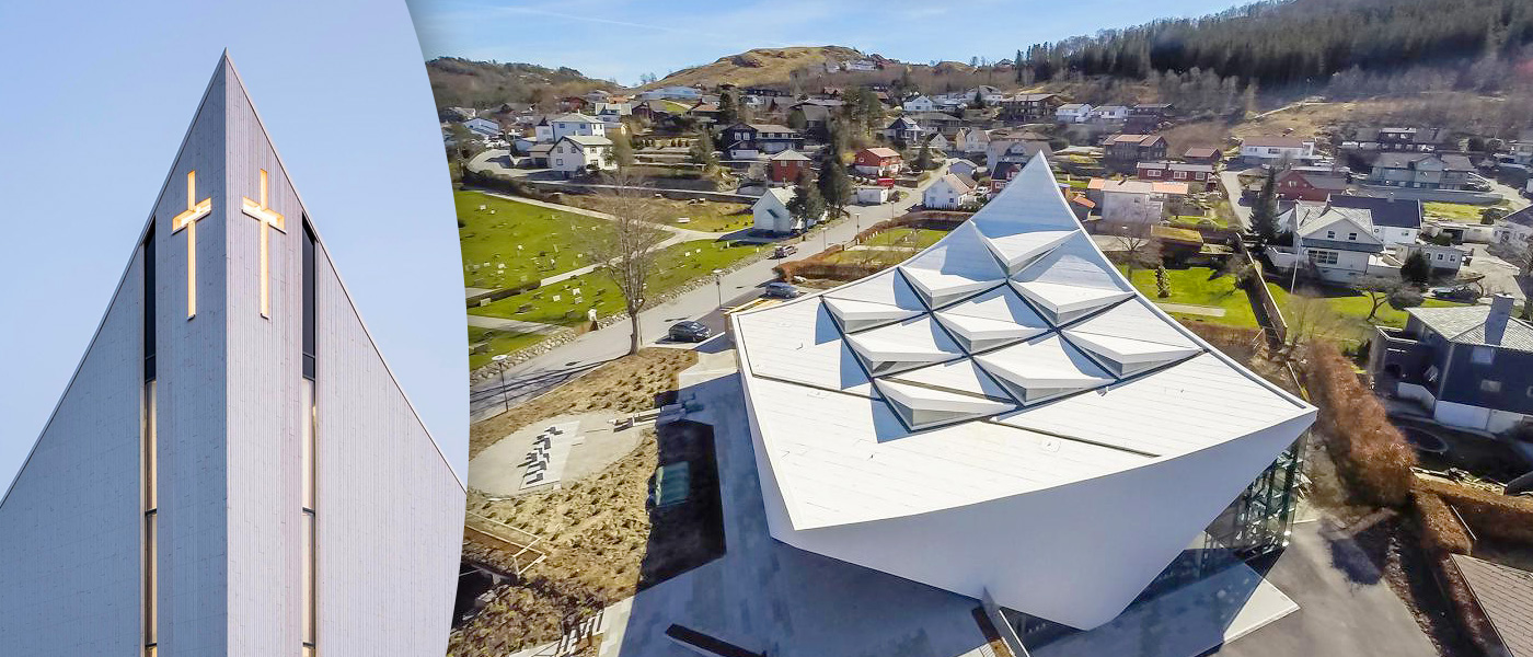 Дневной свет проникает сквозь узкие вертикальные окна в фасаде здания и наполняет изнутри стеклянную колонну за престолом алтаря